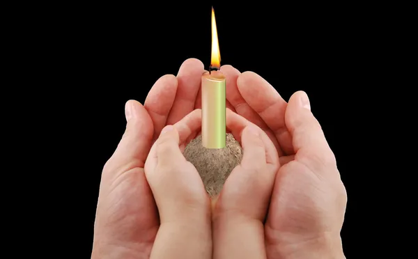 Hände und eine Kerze — Stockfoto