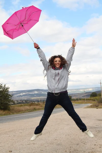 傘を持つ幸せな女性をジャンプ ロイヤリティフリーのストック画像