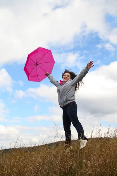 Saltando senhora feliz com guarda-chuva rosa — Fotografia de Stock