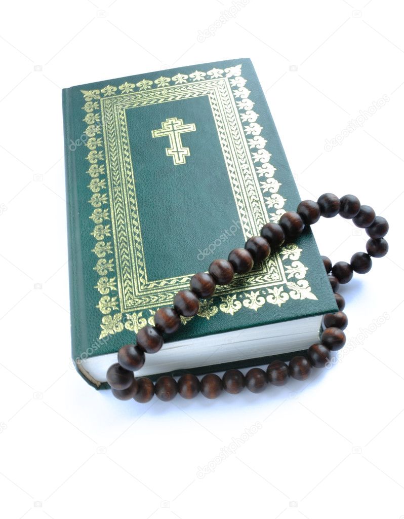 Closing bible of the green colour with gold(en) ornament and rosary beads overhand