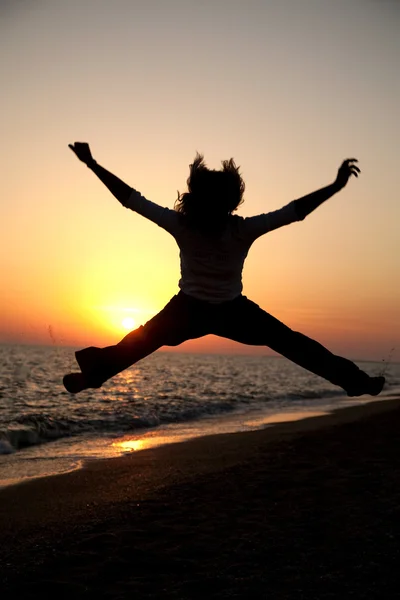 Joven chica adulta saltar en la puesta del sol — Foto de Stock