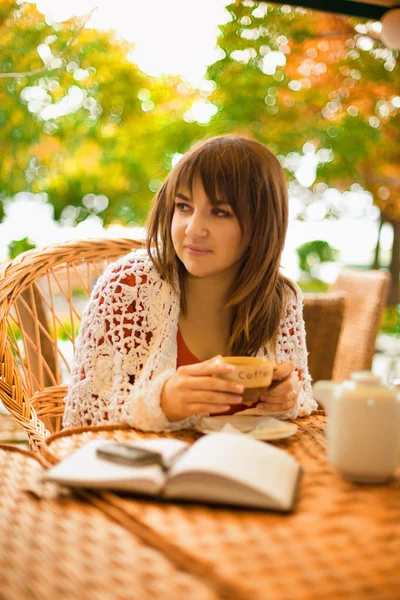 若い女性が屋外のカフェでお茶を飲む — ストック写真