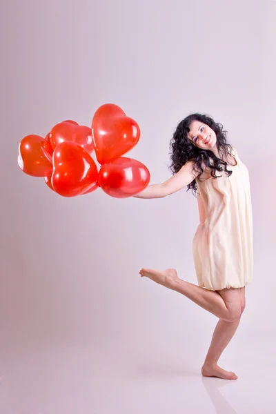 Mulher com balão de coração vermelho em um fundo branco — Fotografia de Stock