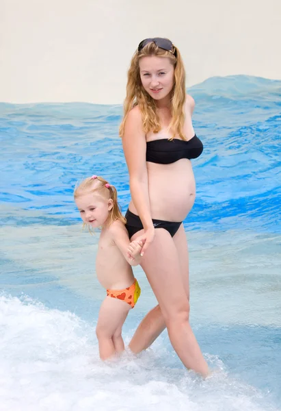 Těhotná žena s dítětem na pláži — Stock fotografie