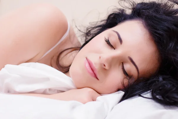 Mooie vrouw liggen en slapen op het besneeuwde bed — Stockfoto