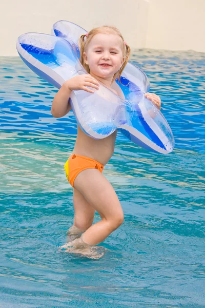 Little girl playing in blue water — Stock Photo, Image