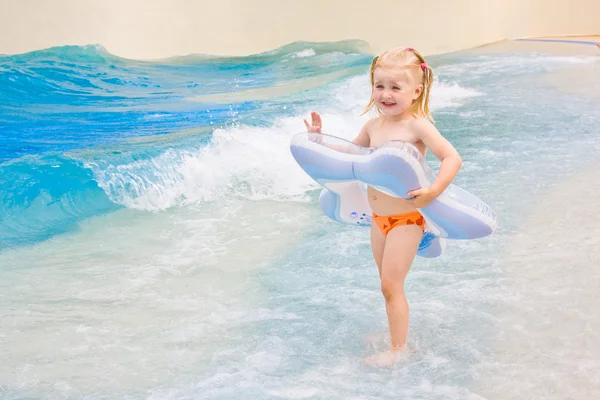 Malá holčička hraje v modré vodě — Stock fotografie