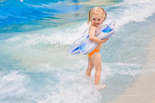 Little girl playing in blue water — Stock Photo, Image