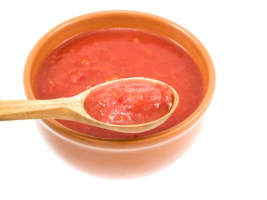 The spoon from a tree full of sauce is located near a plate clipart