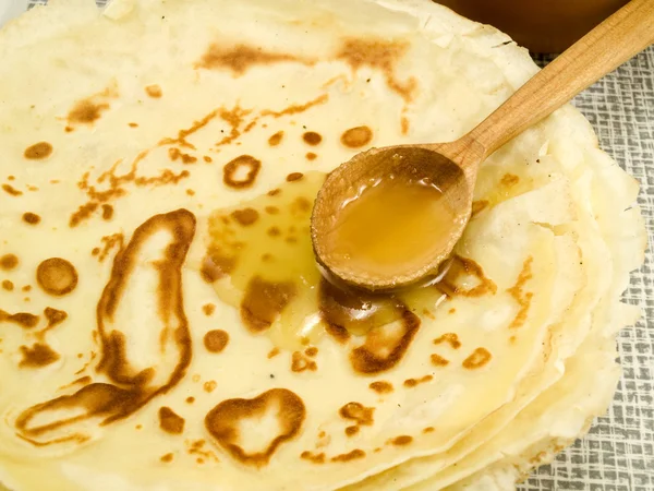 stock image Pancakes fill with honey by means of a wooden spoon