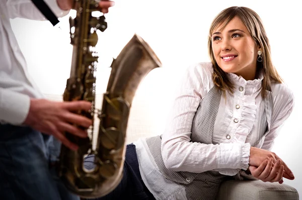 Homem joga o saxofone para linda namorada — Fotografia de Stock