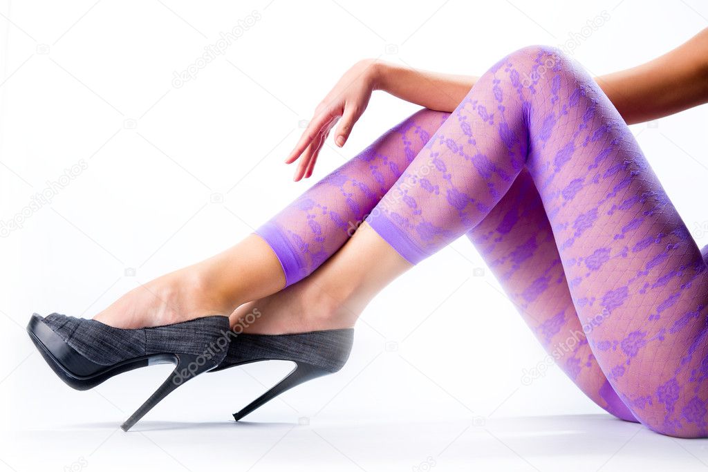 Female legs in purple leggings and high heels