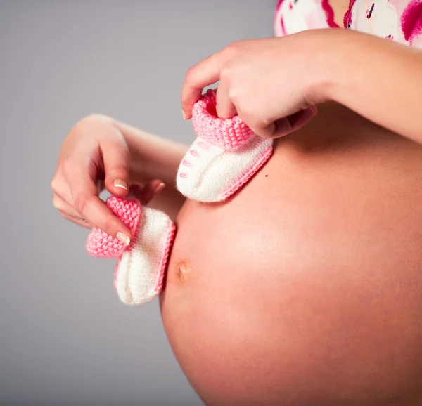 Zwangere vrouw en slofjes — Stockfoto