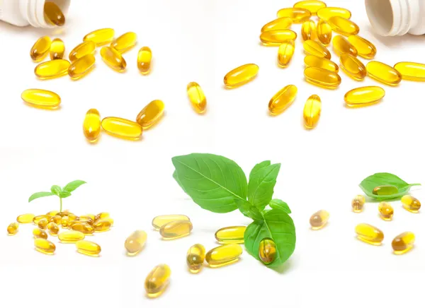 ビタミンの丸薬と緑の葉のセット — ストック写真