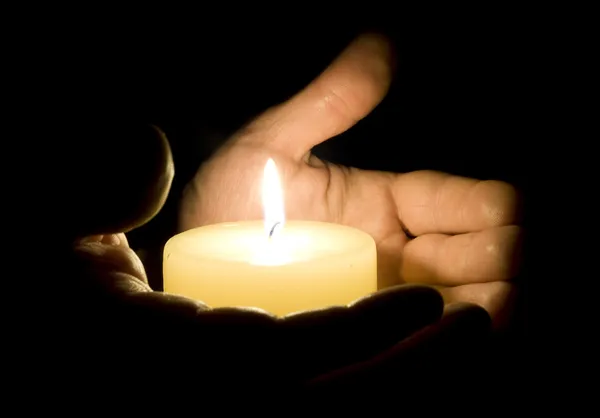 Человеческие руки держат свечу — стоковое фото