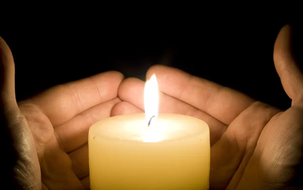 Mãos a tentar salvar a luz da vela — Fotografia de Stock