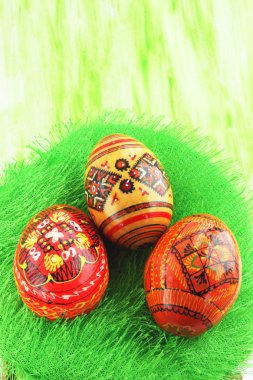 Three eggs with the manual painting against the green background clipart