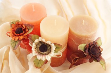 Three large candle with the flowers on the cloth clipart