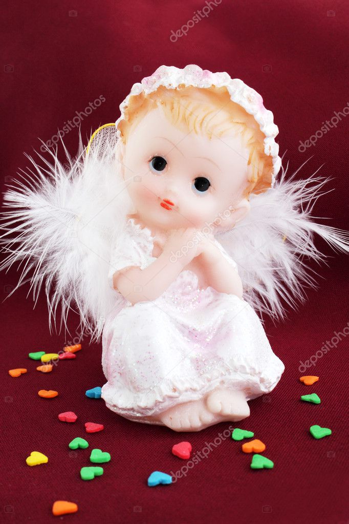 White angel in the guise of child against the dark background