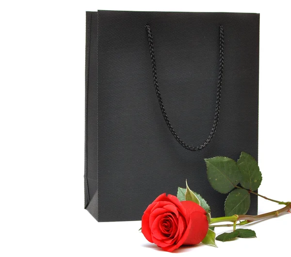 Schwarze Geschenktüte mit roter Rose — Stockfoto