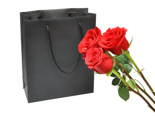 Черный подарочный пакет с красными розами — стоковое фото