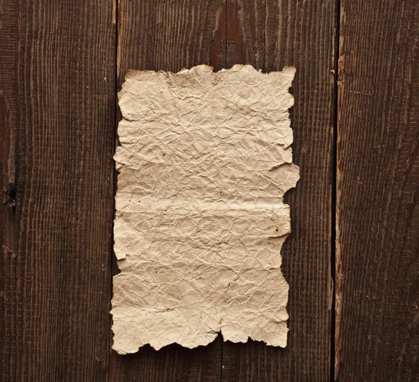 Oud papier op bruin houtstructuur — Stockfoto