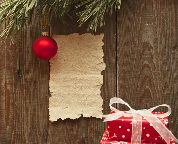 Рождественские украшения и старая бумага на коричневой текстуре дерева — стоковое фото