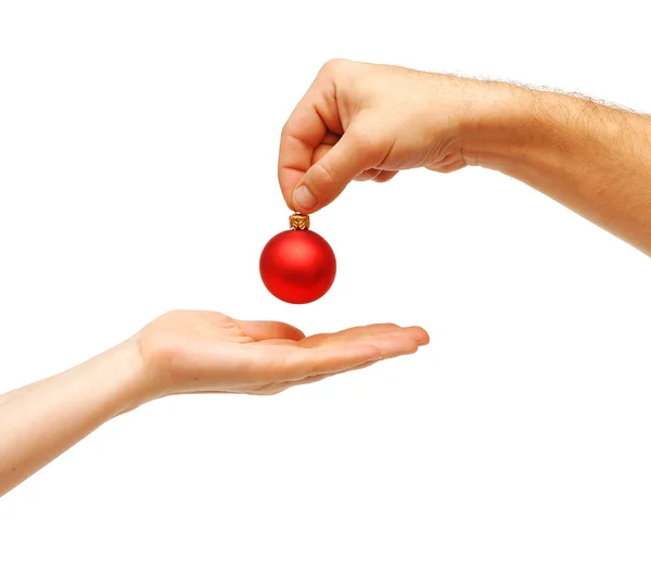 Les mains masculines donnent une boule de Noël aux mains féminines — Photo