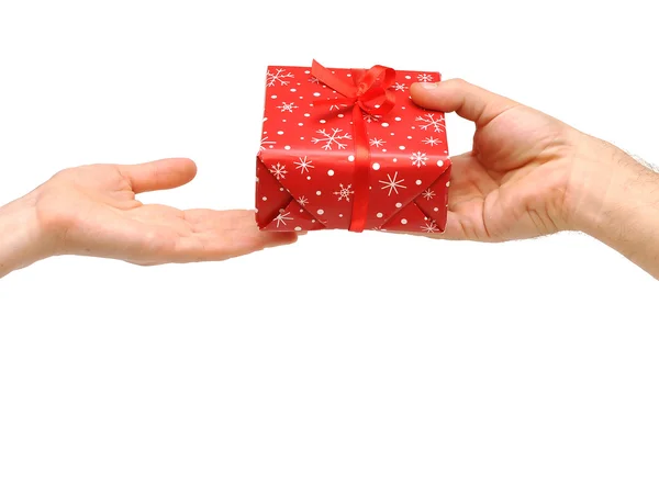 Férfi kezébe adni egy karácsonyi ajándék, piros szalaggal női hektár — Stock Fotó