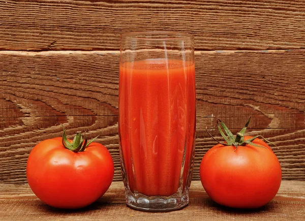 Pomodori freschi e un bicchiere pieno di succo di pomodoro — Foto Stock