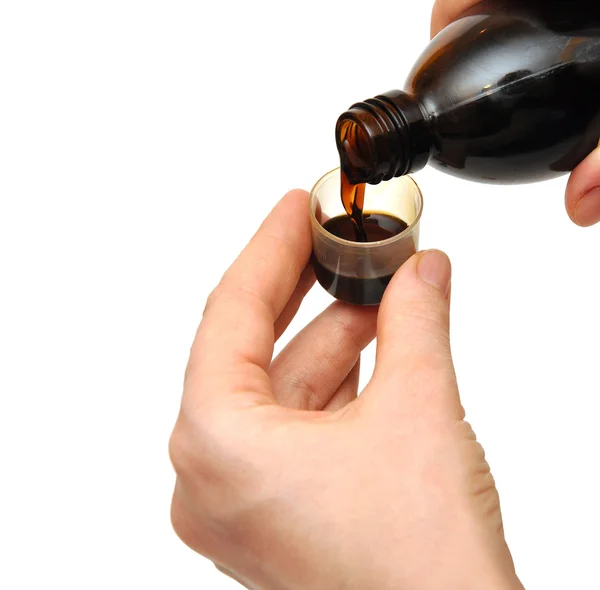 Наливание жидких лекарств женскими руками от бутылок до измерений — стоковое фото