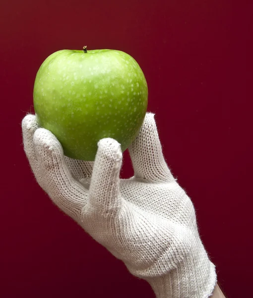 Рука Білій Рукавичці Тримає Яблуко Червоному Тлі — стокове фото