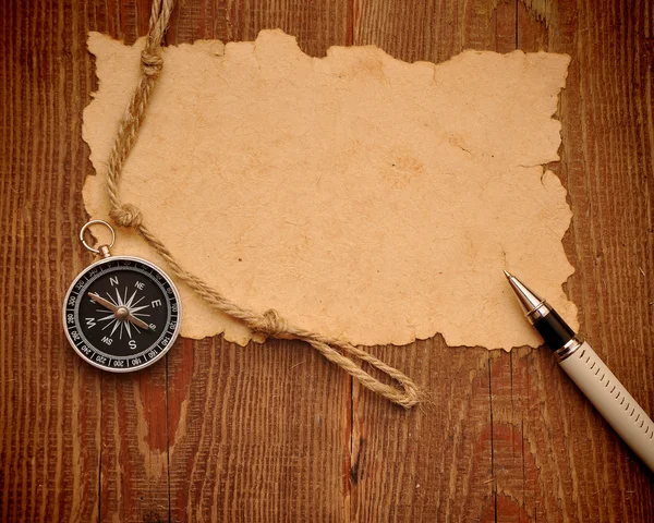 Старая бумага, компас, ручка и веревка на фоне гранжа — стоковое фото