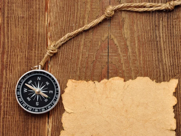 Kompas i liny na tle drewna — Zdjęcie stockowe