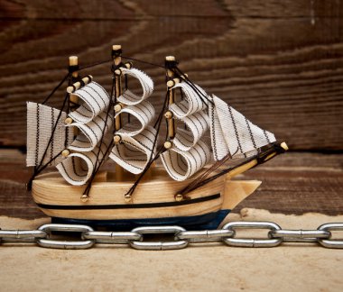 Model ship on wood background clipart