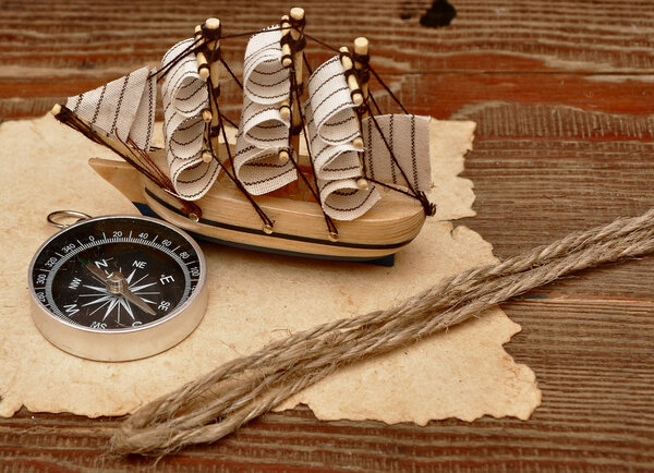 Old paper, rope and model classic boat on wood background