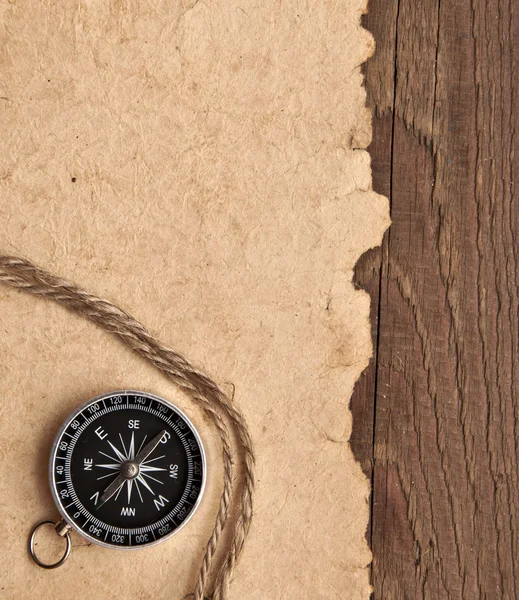 Bússola e corda sobre fundo de madeira — Fotografia de Stock