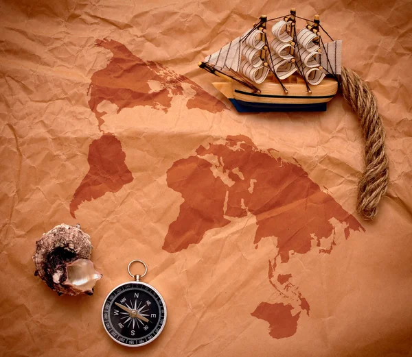 Kompass, Muschel und Bootsmodell auf altem Papier — Stockfoto