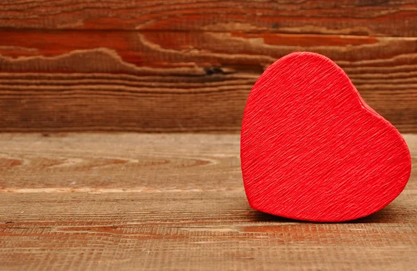 Червона коробка у формі серця на фоні дерева — стокове фото