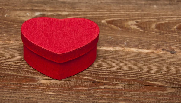 Kalp Şeklinde Ahşap Arka Plan Üzerinde Kırmızı Bir Kutu — Stok fotoğraf