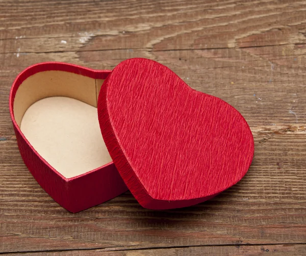 Czerwone pudełko w kształcie serca na tle drewna — Zdjęcie stockowe