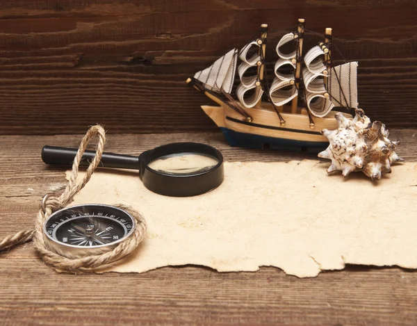 Старая бумага и модель классической лодки на деревянном фоне — стоковое фото