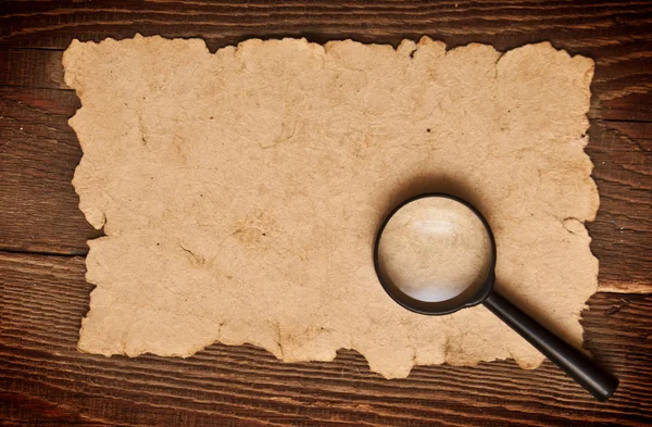 Magnifying glass on old paper — Stock Photo, Image