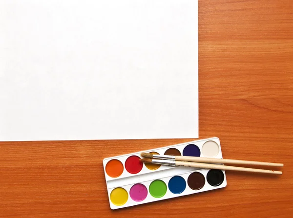 Watercolor paints set with brushes and paper sheet — Stock Photo, Image