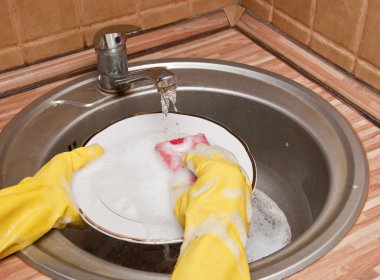 Washing dishes under running water clipart