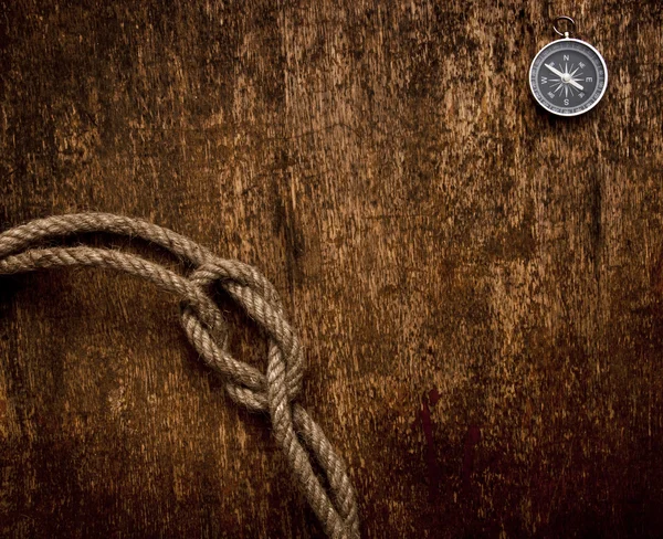 Kompass und Seil auf Grunge-Hintergrund — Stockfoto