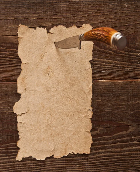 Papel velho preso a uma parede de madeira com uma faca — Fotografia de Stock