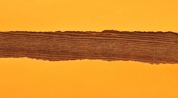 木製の背景にオレンジの破れた紙 — ストック写真