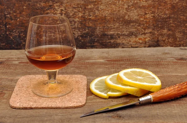 Classic cognac with lemon and knife — Stock Photo, Image