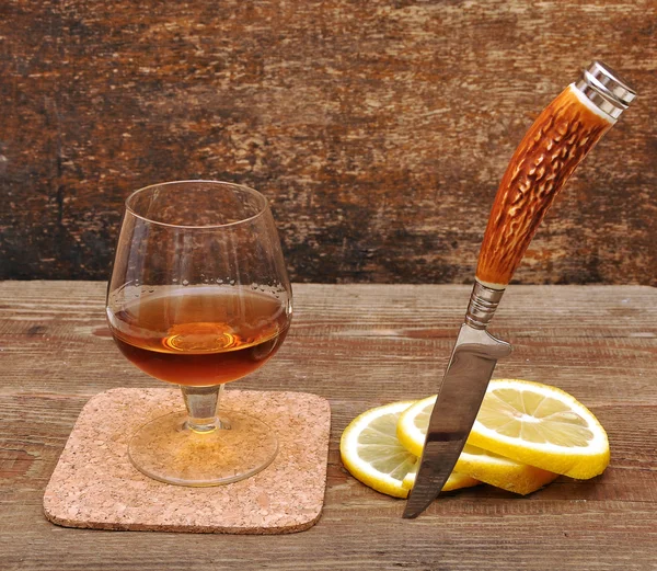 Classic cognac with lemon and knife — Stock Photo, Image